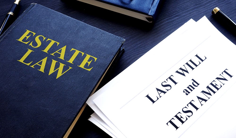 Estate Planning law book and will and testament document on a desk.