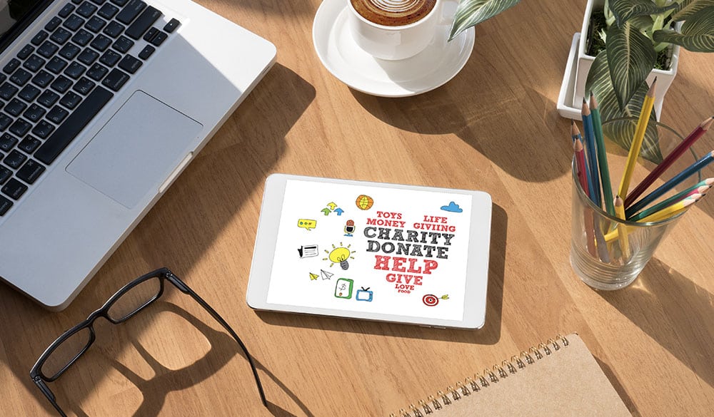 Ipad and laptop on a desk showing graphics related to non-profit organizations