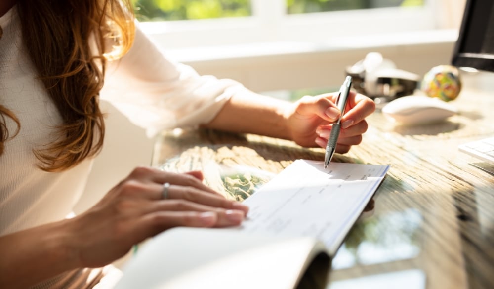 Accountant signing a check for a business payroll
