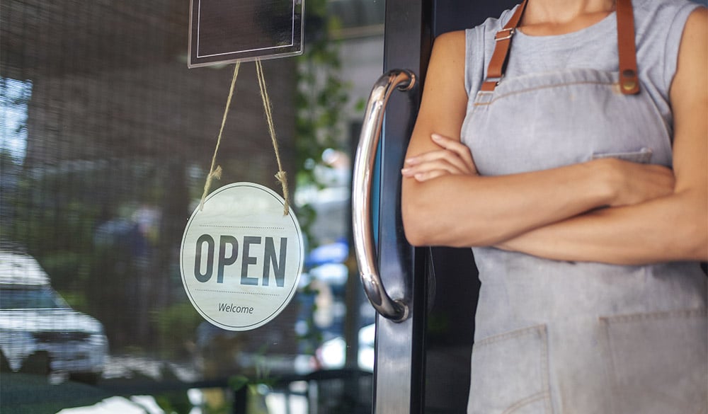 Small business owner standing in doorway of shop